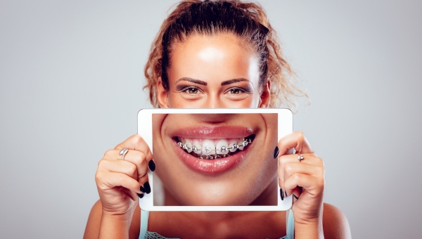 dental braces patient showing her smile on an ipad mobile application for orthodontists