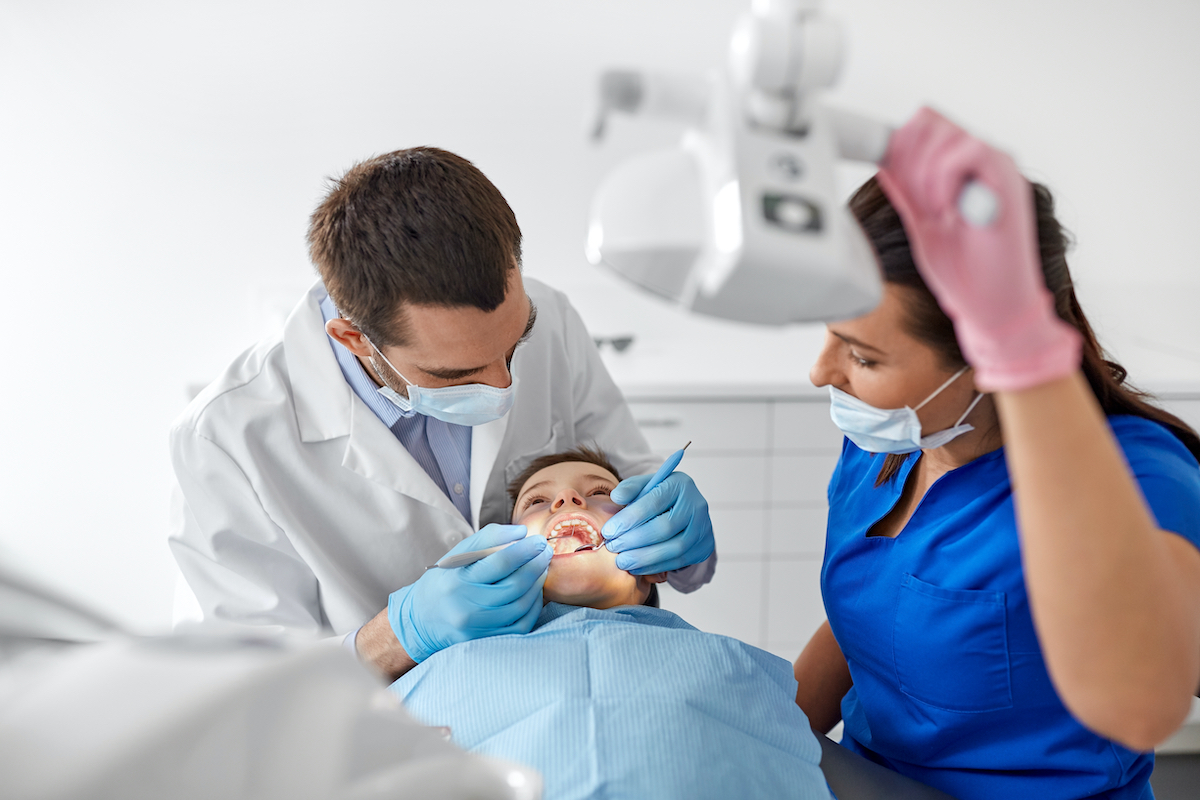 Dentist and hygienist examining a child's teeth