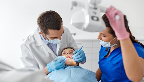 Dentist and hygienist examining a child's teeth