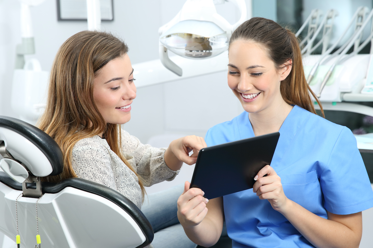 Dentist using OrthoPhoto App with patient during appointment