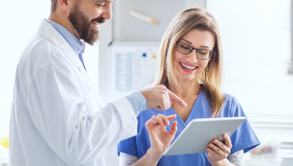 Two dentists using a tablet for recordkeeping