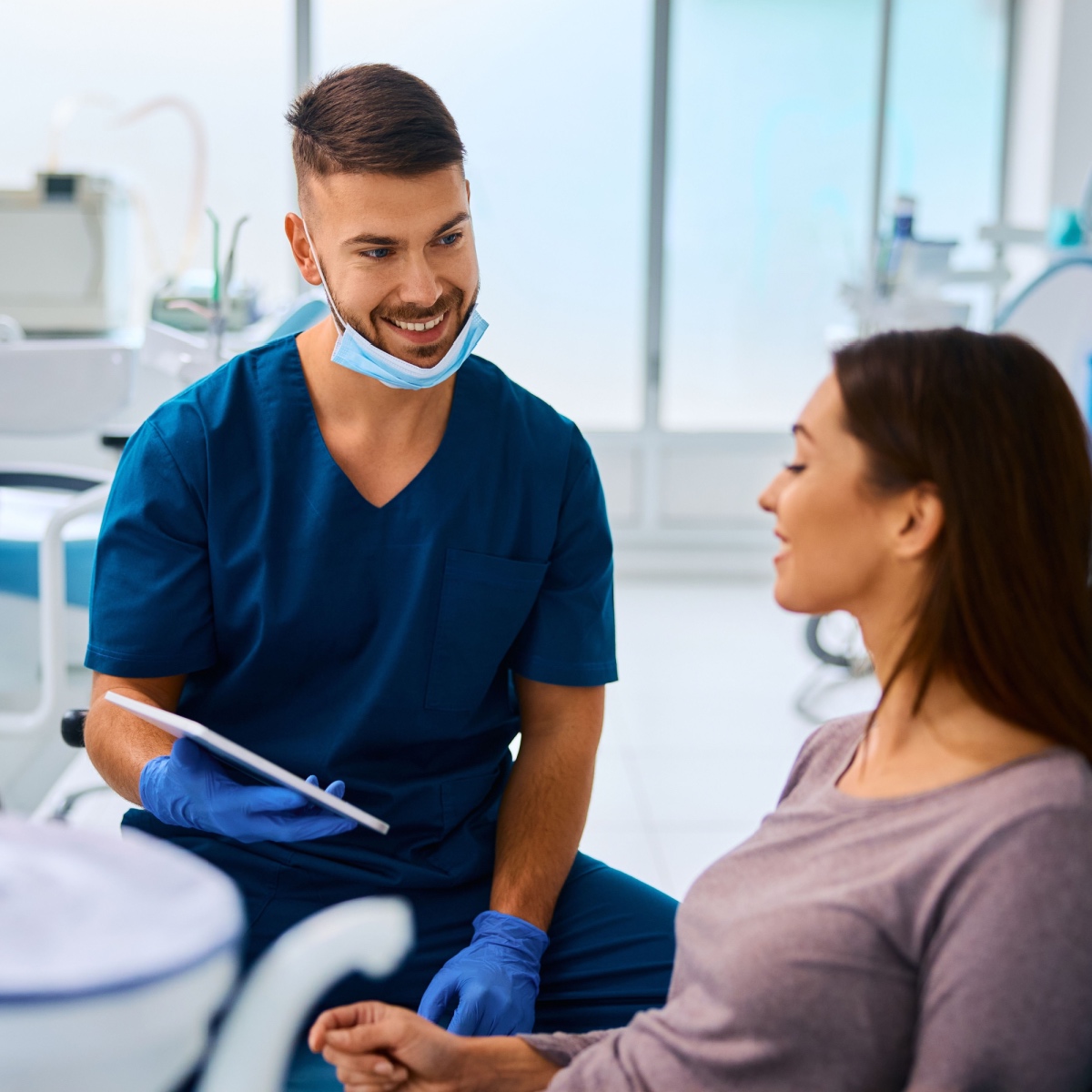 A happy dentist holding the OrthoPhoto dental recordkeeping app