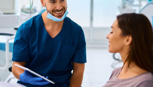 A happy dentist holding the OrthoPhoto dental recordkeeping app