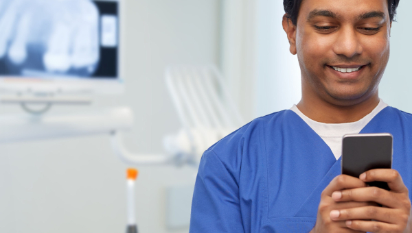 A dentist using the OrthoPhoto app on his phone