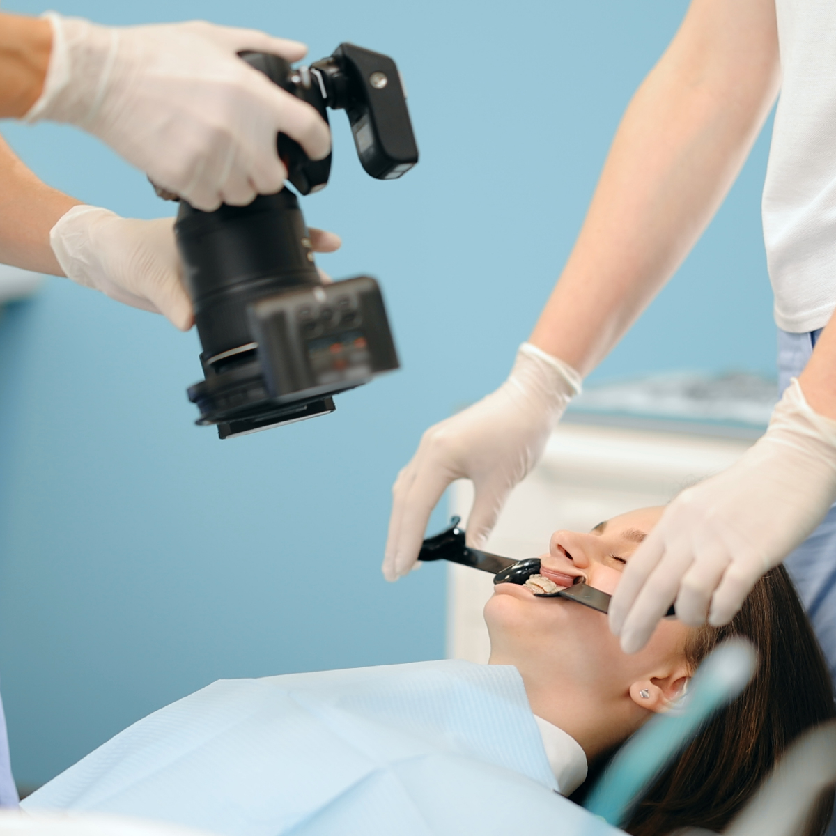 An orthodontist photographing the patient's teeth