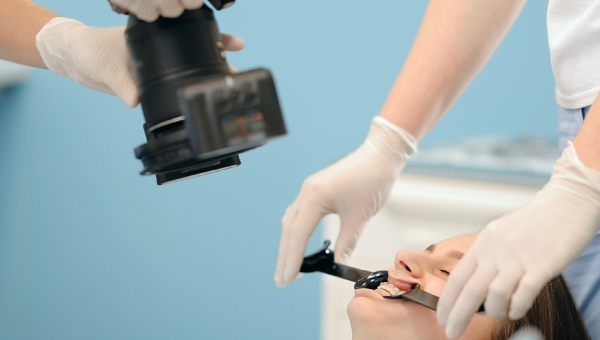 An orthodontist photographing the patient's teeth
